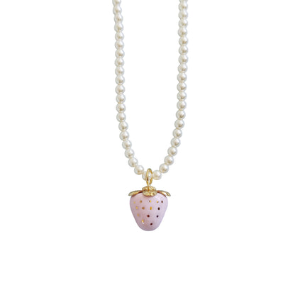 Mini pale pink porcelain strawberry pendant with hand-painted gold dots on a Swarovski glass pearl necklace.